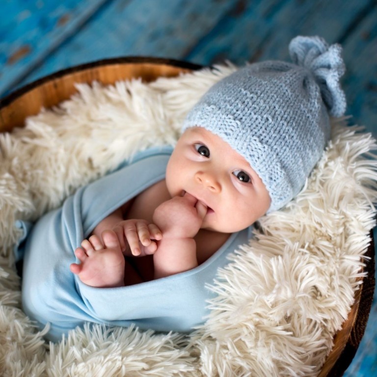 Baby boy in blue crochet hat and blanket